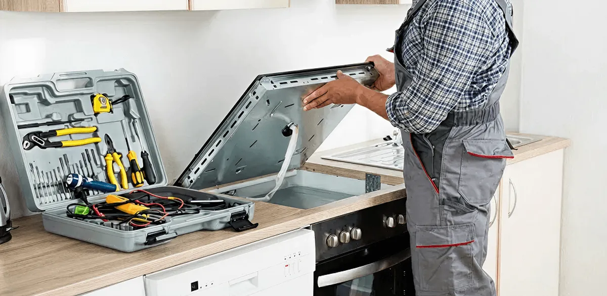 Handyman repairing a cooktop and checking wiring connections in Hialeah, FL