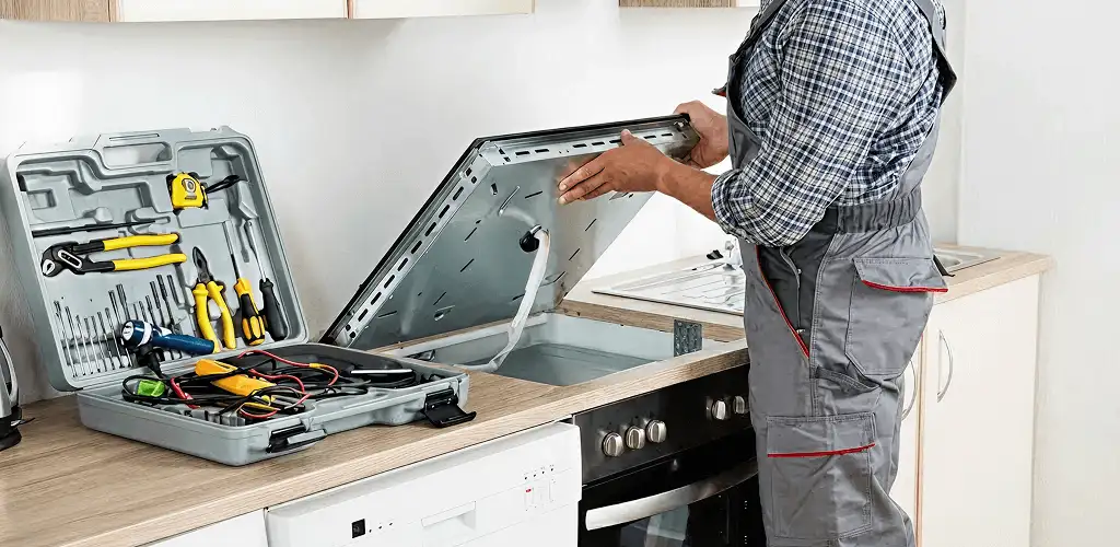 Handyman repairing a cooktop and checking wiring connections in Hialeah, FL