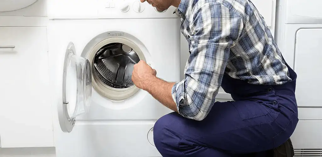 Handyman inspecting a dryer drum and internal parts for repair in Hialeah, FL