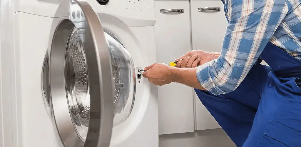 Handyman repairing a clothes dryer and checking electrical connections in Hialeah, FL