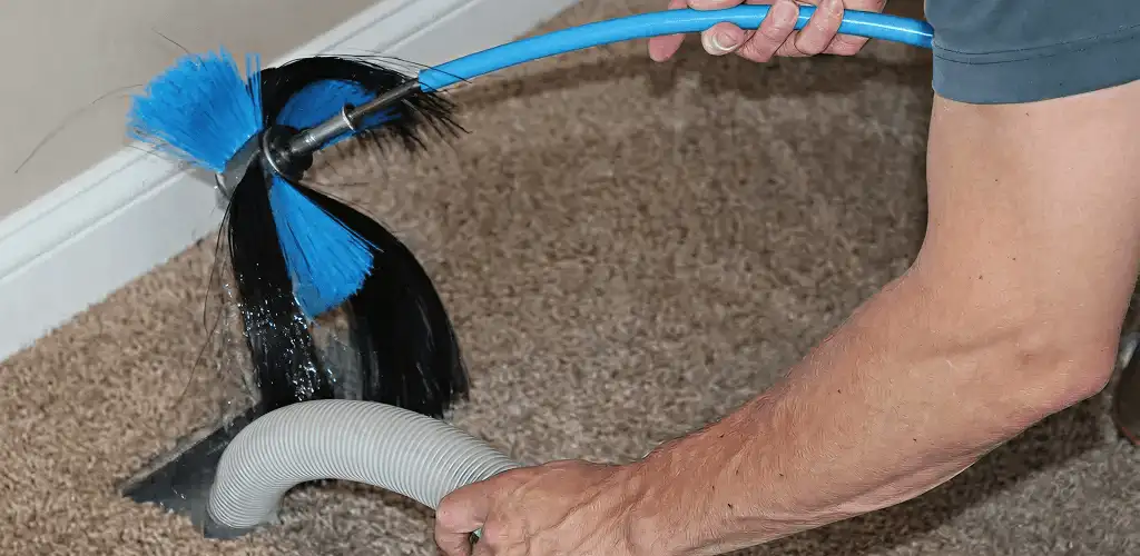 Dryer vent cleaning technician brushing lint from a vent line in Hialeah, FL
