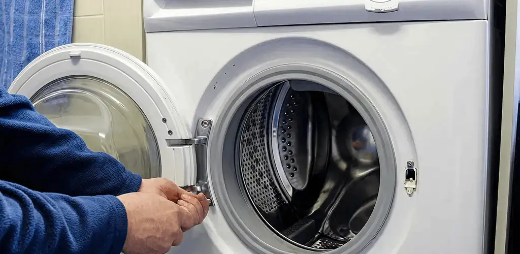Washing machine repair handyman checking a front-load washer door and latch in Hialeah, FL