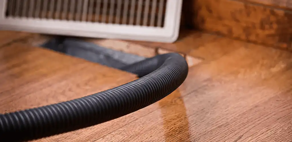 Air duct cleaning hose inserted into a floor vent for ductwork cleaning in Hialeah, FL